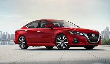 2023 Nissan Altima in red with city in background illustrating last year's 2022 model in Taylor's Auto Max Nissan in Great Falls MT