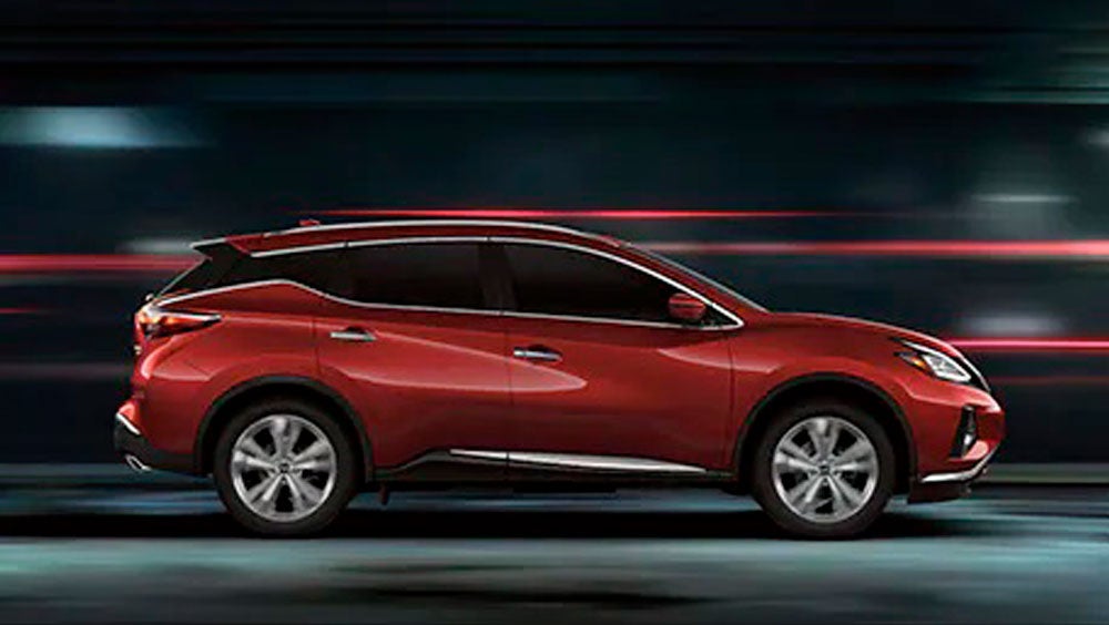 2023 Nissan Murano shown in profile driving down a street at night illustrating performance. | Taylor's Auto Max Nissan in Great Falls MT