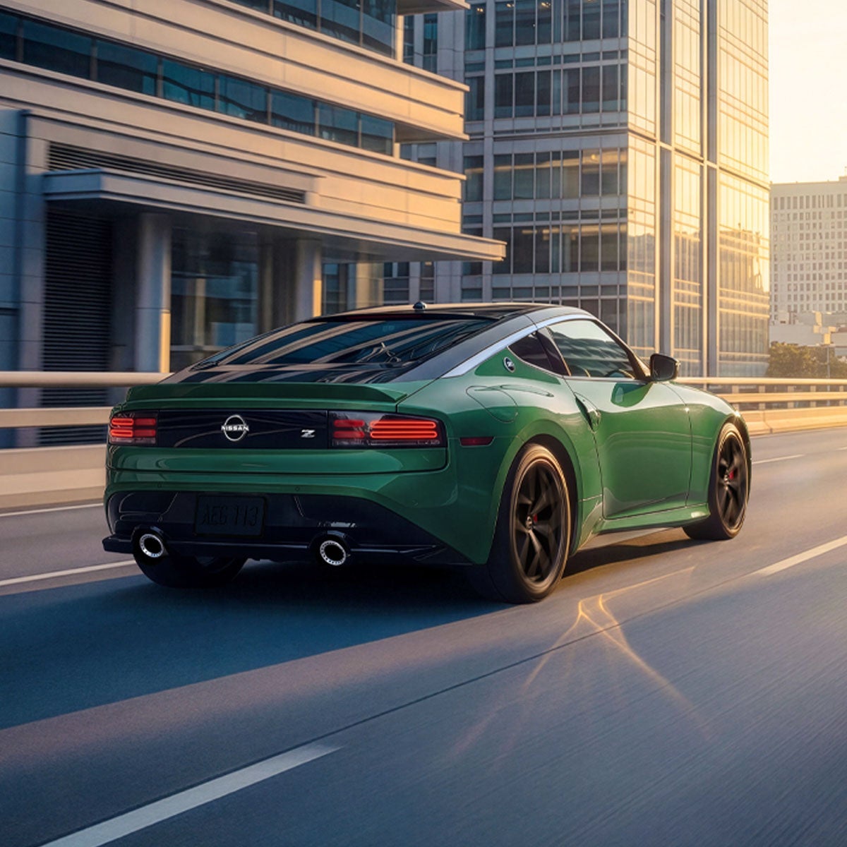 Rear view of a new green Nissan Z sports car driving on a multi-lane highway in a city at sunset.